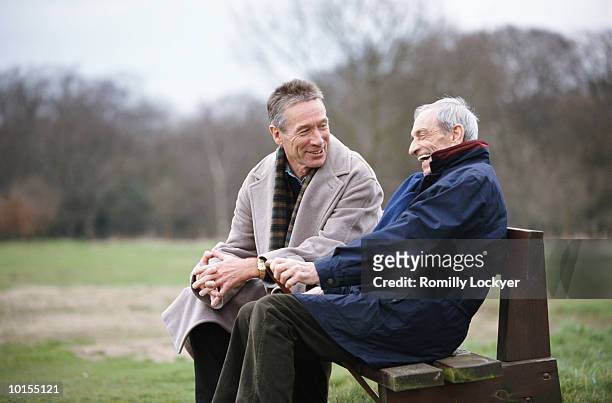80s father and 50s son on park bench, uk - senior adult stock-fotos und bilder