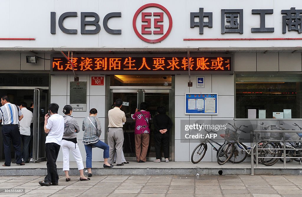 Chinese people queue up outside a bank a