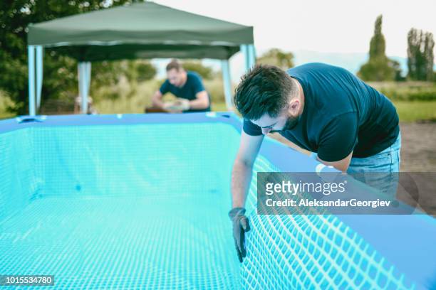 shop workers setting up swimming pool - swimming pool cleaning stock pictures, royalty-free photos & images