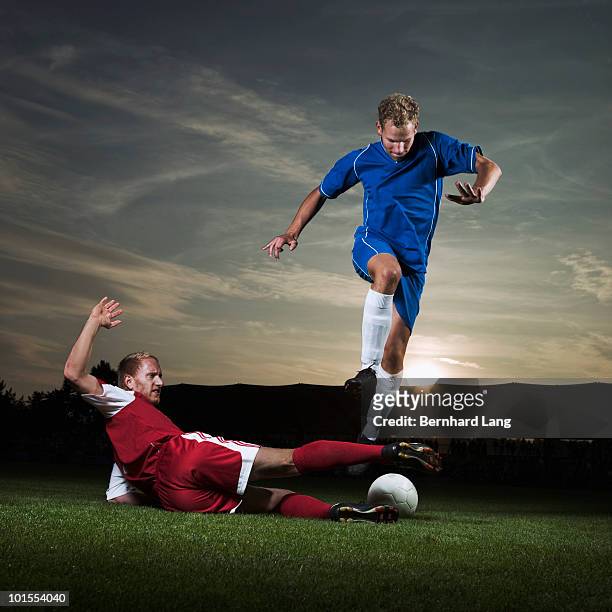 two soccer player fighting for ball  - tackling stockfoto's en -beelden