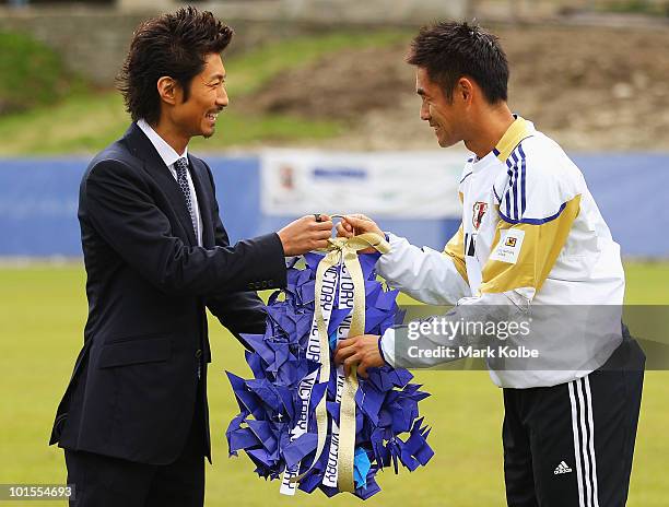 Makidai of the all-male Japanese pop band and dance group Exile presents a gift to Yoshikatsu Kawaguchi during a visit to a Japan training session at...