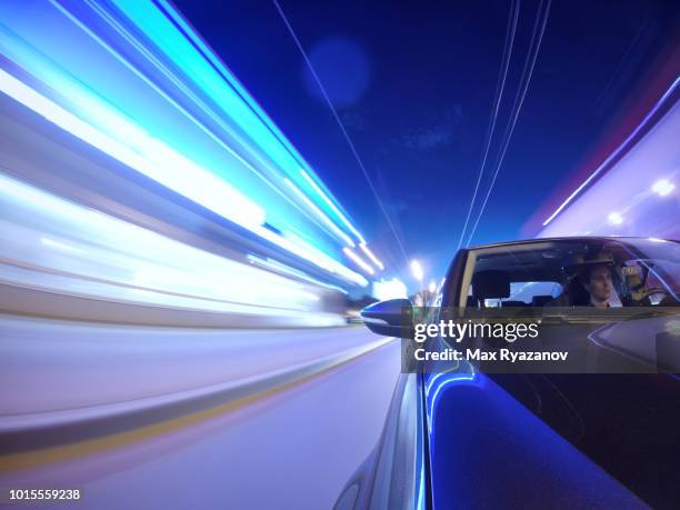 front view of the car while driving in the city at night. shooting at long exposure. light traces of illumination of buildings and road - car front view stock pictures, royalty-free photos & images