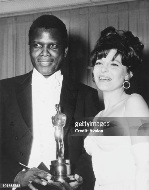 American actress Anne Bancroft with Sidney Poitier after she presented him with the Academy Award for Best Actor in a Leading Role, at the Beverly...