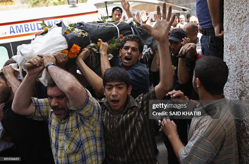 Palestinian mourners carry the body of M