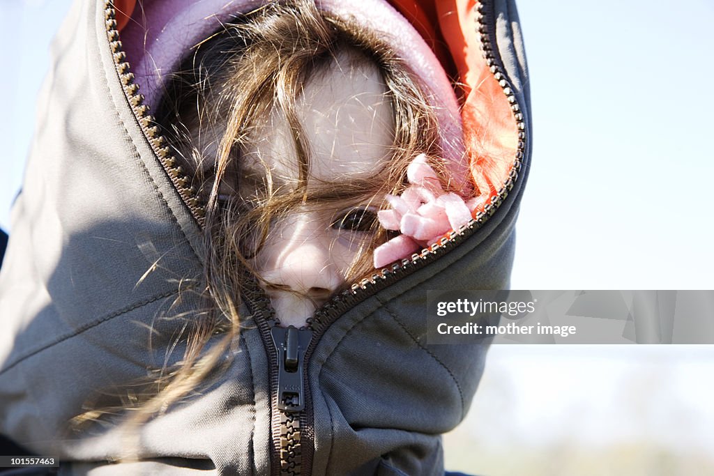 Girl in winter coat zippered all the way up