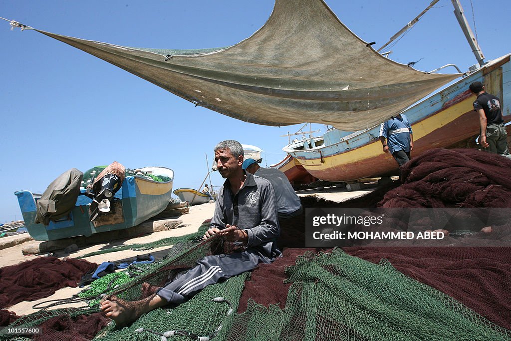A Palestinian fisherman repairs his nets