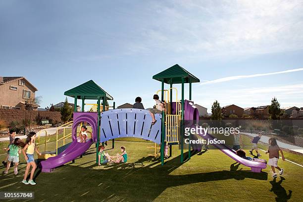 kids playing on playground slides outdoors - playground stock pictures, royalty-free photos & images
