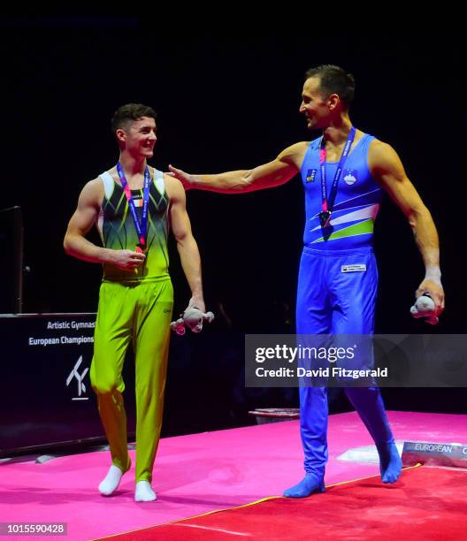 Glasgow , United Kingdom - 12 August 2018; Rhys McClenaghan of Ireland, left, is congratuled by silver medallist Saso Bertoncelj of Slovakia after...