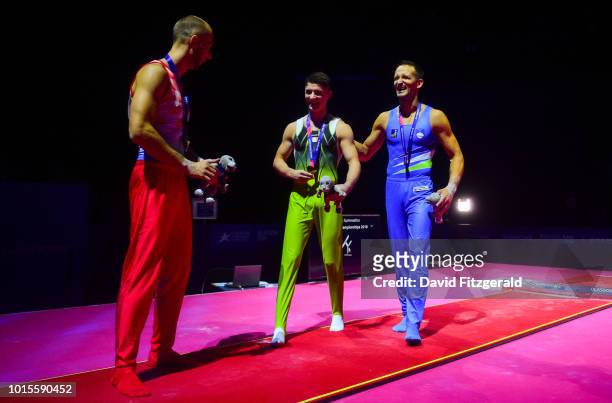 Glasgow , United Kingdom - 12 August 2018; Rhys McClenaghan of Ireland, left, is congratuled by silver medallist Saso Bertoncelj of Slovakia, right,...