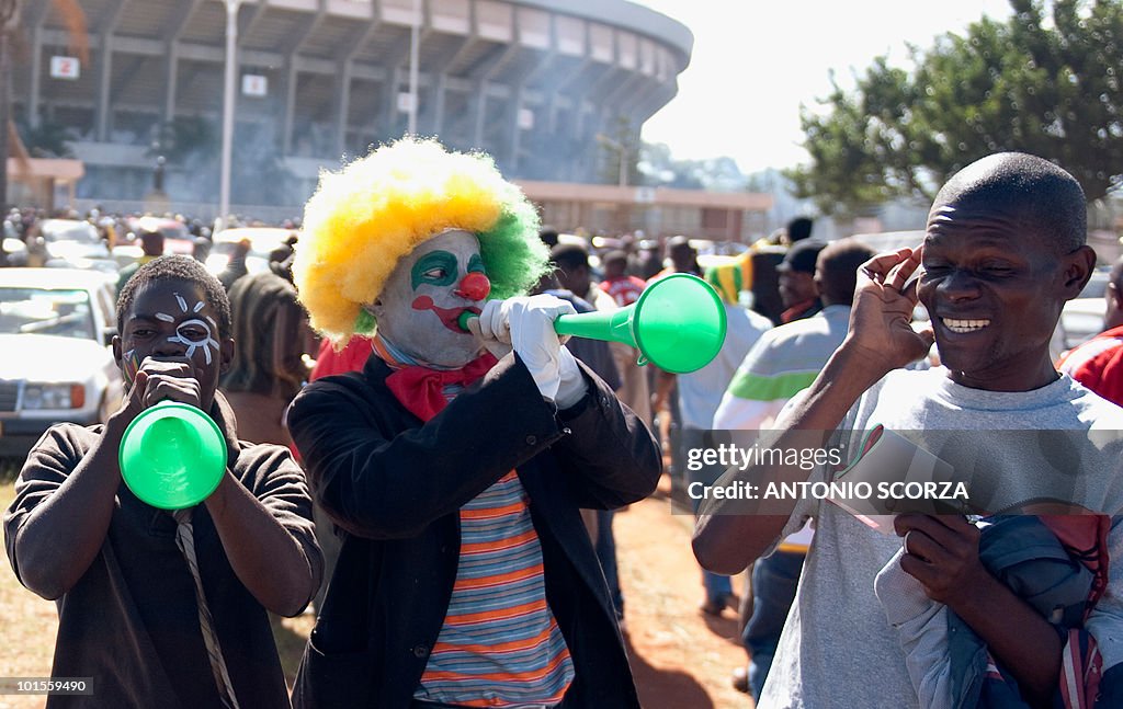 Zimbabweans football fans play the vuvuz