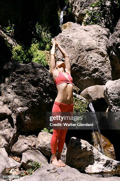 yoga poses in front of water creek. - giordani walter stockfoto's en -beelden