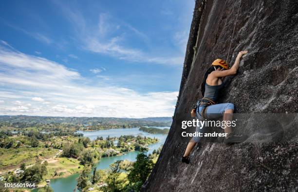 starke frau klettern am guatape in kolumbien - felsklettern stock-fotos und bilder