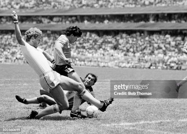 Deigo Maradona of Argentina goes past Terry Butcher and goalkeeper Peter Shilton of England as he scores Argentina's second goal during a World Cup...