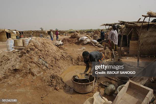 Female gold miner filters mud hoping to find gold in Namisgma on May 9, 2010. Namisgma is the most important gold site in Burkina Faso and is...