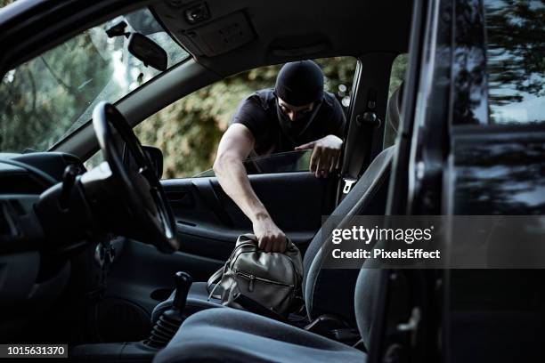 thief stealing handbag from car - black purse stock pictures, royalty-free photos & images