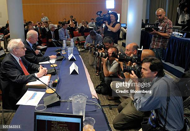 Warren Buffett, chairman and chief executive officer of Berkshire Hathaway Inc., front left, and Raymond McDaniel, chairman and chief executive...