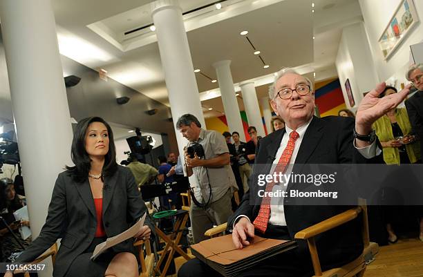 Warren Buffett, chairman and chief executive officer of Berkshire Hathaway Inc., right, gets ready for an interview with Betty Liu of Bloomberg...