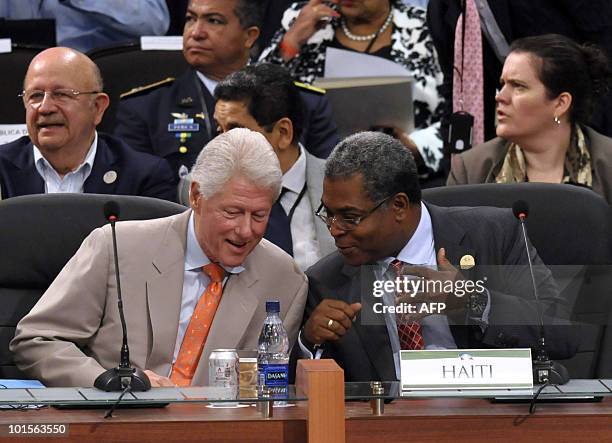 Former US president and special UN representative for Haiti Bill Clinton speaks with the Prime Minister of Haiti Jean Max Bellerive during the...