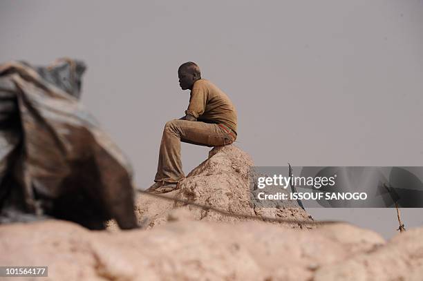 Gold miner takes a break after coming out of a hole where he was digging and looking for gold in Namisgma, the largest gold washing site in the...