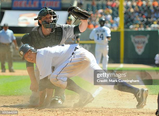 Brandon Inge of the Detroit Tigers is tagged out at home plate by Landon Powell of the Oakland Athletics during the game at Comerica Park on May 30,...