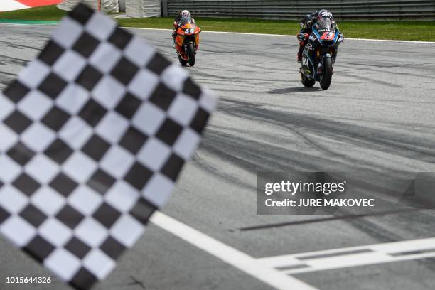 Racing Team VR46s Italian rider Francesco Bagnaia and Red Bull KTM Ajos Portuguesse rider Miguel Oliveira see the checkered flag during the Moto2...