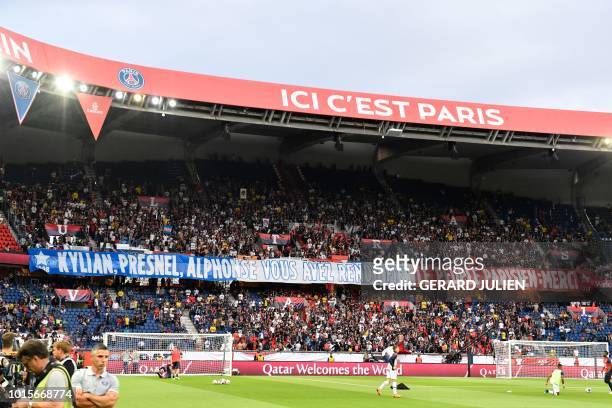 Paris Saint-Germain's supporters hold a banner reading "Kylian, Presnel, Alphonse, you have made the Parisian people proud, thank you" prior to the...