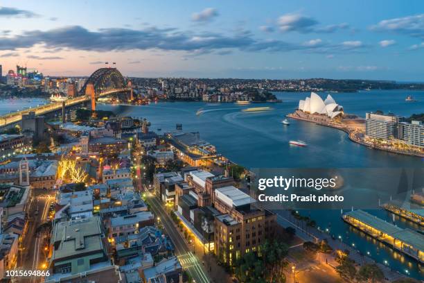 waterfront city skyline of sydney city downtown at night with bright illumination of modern architectural landmarks in sydney, australia. - sydney harbour stock-fotos und bilder