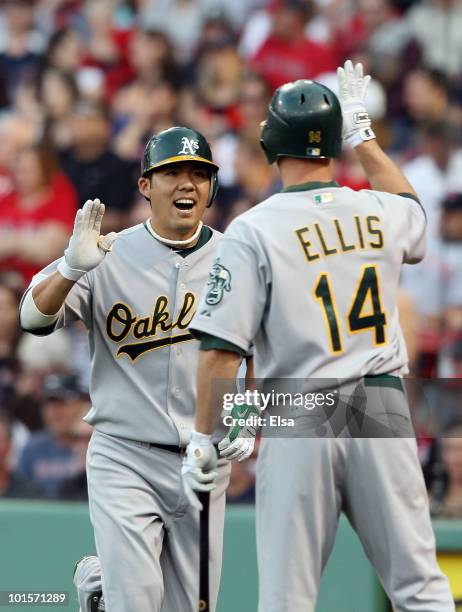 Kurt Suzuki of the Oakland Athletics celebrates with teammate Mark Ellis after Suzuki hit a two run homer in the first inning off a pitch from...