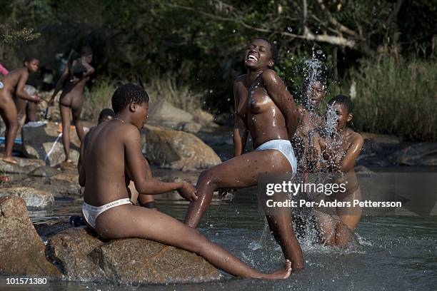 Young girls wash themselves in a river before a traditional Reed dance ceremony at the stadium at the Royal Palace on August 30 in Ludzidzini,...