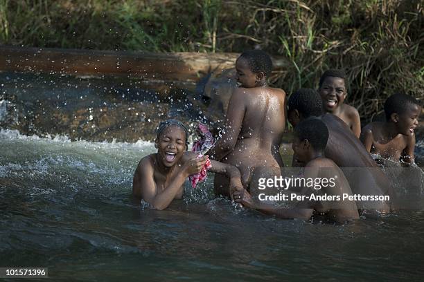 Young girls wash themselves in a river before a traditional Reed dance ceremony at the stadium at the Royal Palace on August 30 in Ludzidzini,...
