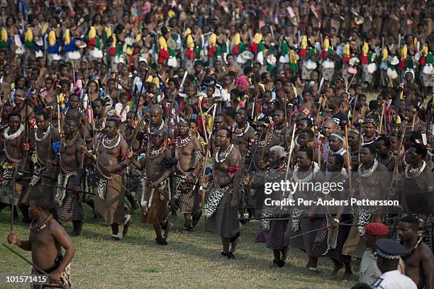 King Mswati III dances with his men in front of young virgins at a traditional Reed dance ceremony at the stadium at the Royal Palace on August 31 in...