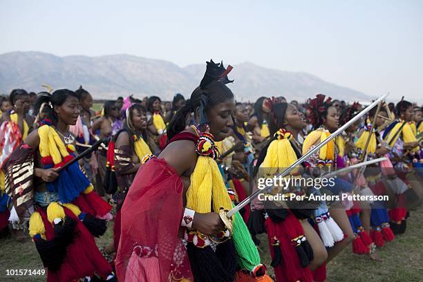 Members of the royal Swazi family dance with young girls dance at a traditional Reed dance ceremony at the stadium at the Royal Palace on August 31...