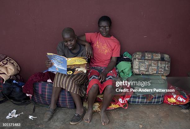 Unidentified girls relax outside their living quarters before a traditional Reed dance ceremony at the Royal Palace on August 31 in Ludzidzini,...