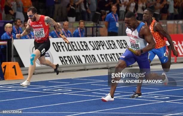 Turkey's Ramil Guliyev , Great Britain's Harry Aikines-Aryeetey and Netherlands' Taymir Burnet cross the finish line of the men's 4x100m relay final...