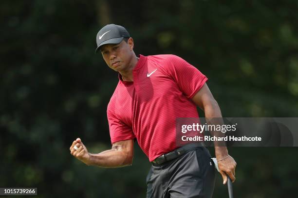 Tiger Woods of the United States reacts after making a putt for birdie on the ninth green during the final round of the 2018 PGA Championship at...