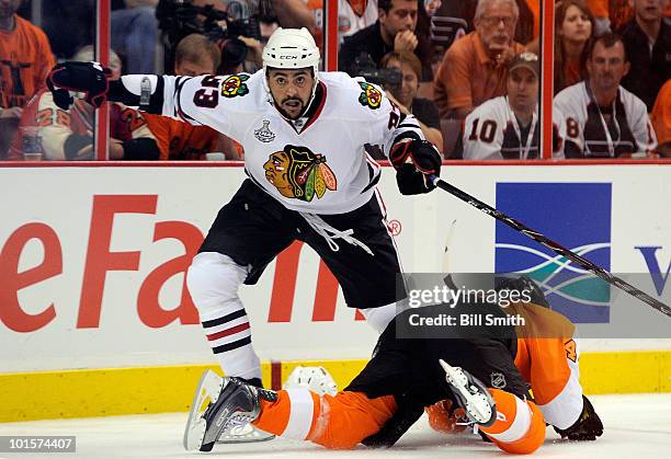 Dustin Byfuglien of the Chicago Blackhawks and Patrick Maroon of the Philadelphia Flyers tangle up behind the net during the third period of Game...