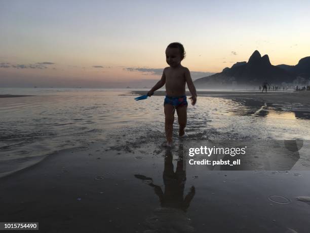 toddler runs ipanema beach sunset water reflection - speedo boy stock pictures, royalty-free photos & images