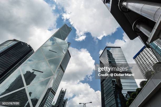 low angle view of skyscraper and luxury hotel towers in hong kong island central district with a dramatic sky in hong kong - central stock pictures, royalty-free photos & images