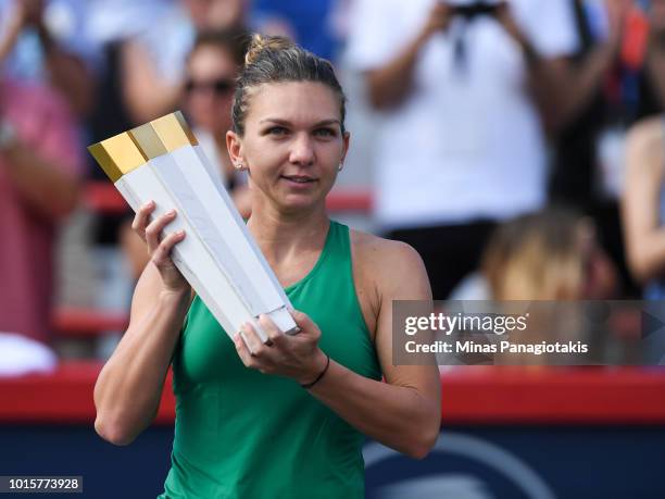 Simona Halep of Romania holds up the trophy during the post game ceremony after defeating Sloane Stephens 7-6, 3-6, 6-4 in the final on day seven of...