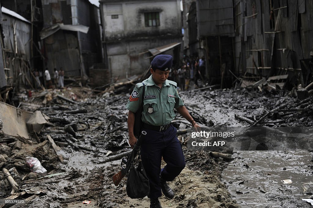 A Bangladeshi policeman walks on the sit