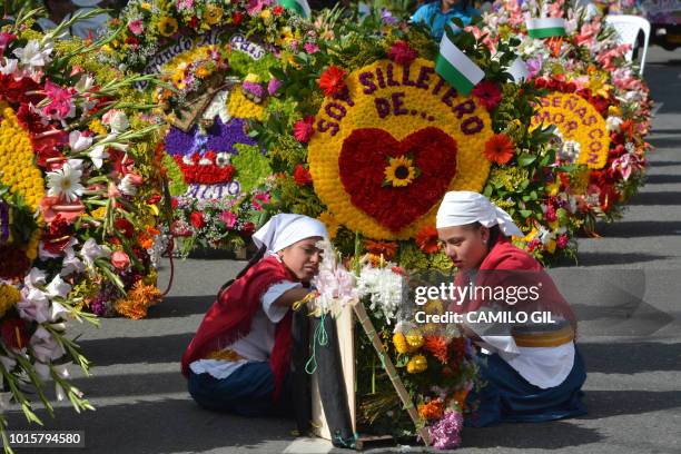 Women prepare flower arrangements before the traditional "Silleteros" parade, held as part of the Flower Festival in Medellin, Antioquia department,...