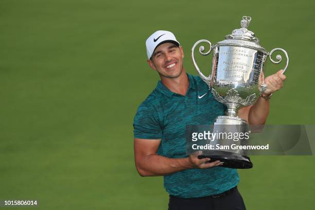 Brooks Koepka of the United States poses with the Wanamaker Trophy on the 18th green after winning the 2018 PGA Championship with a score of -16 at...