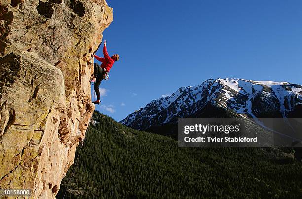 male climber on steep alpine cliff, aspen - soloklettern stock-fotos und bilder