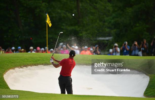 Tiger Woods of the United States plays a shot from a bunker on the 17th hole during the final round of the 2018 PGA Championship at Bellerive Country...
