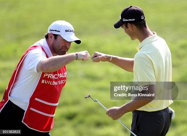 Martin Kaymer of Germany celebrates with his caddie Craig Connelly after a birdie on the 15th hole during the first round of the Celtic Manor Wales...