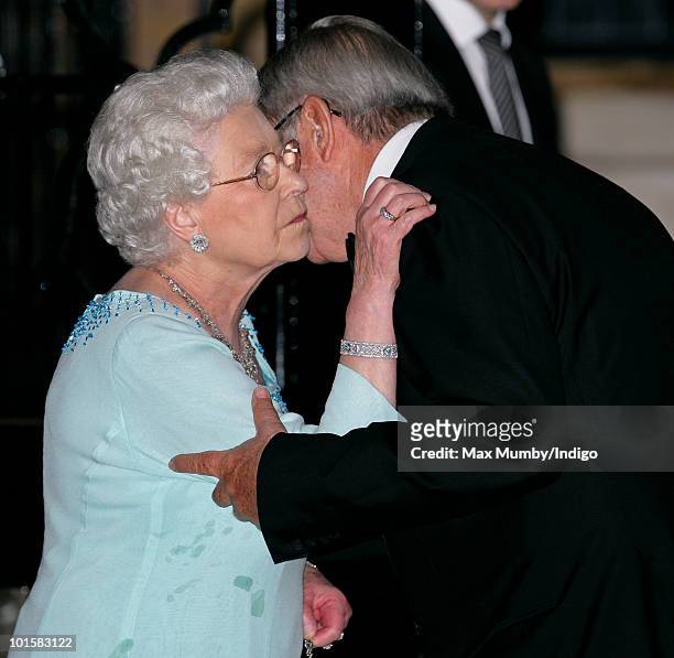 Queen Elizabeth II kisses King Constantine of Greece goodbye as she leaves his 70th birthday party at Crown Prince Pavlos of Greece's residence on...