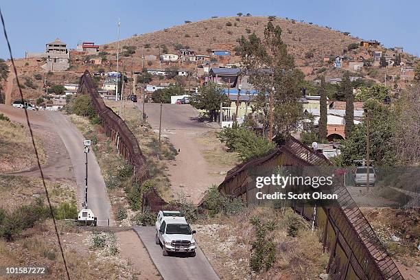 Customs and Border Protection agent drives along a fence which separates the cities of Nogales, Arizona and Nogales, Sonora Mexico, a frequent...
