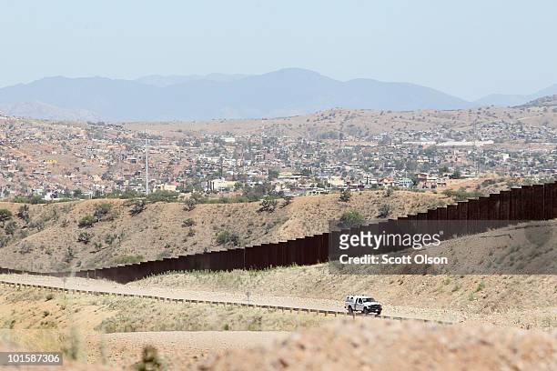 On the outskirts of town, a U.S. U.S. Customs and Border Protection agent drives along a fence which separates the cities of Nogales, Arizona and...
