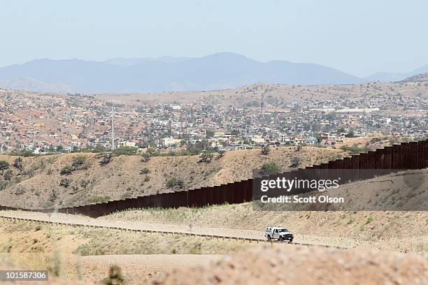 On the outskirts of town, a U.S. U.S. Customs and Border Protection agent drives along a fence which separates the cities of Nogales, Arizona and...