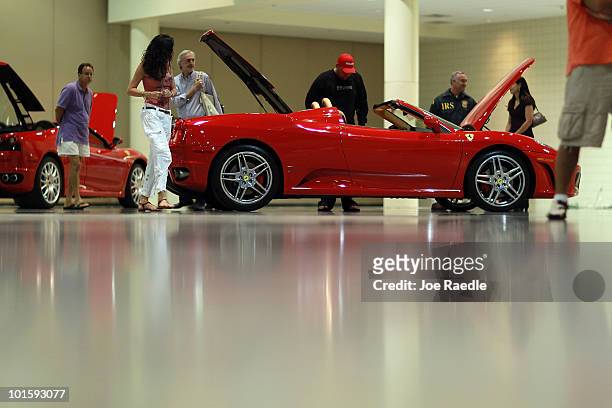 People check out the Ferrari cars before the auction put on by Rick Levin and Associates, Inc., on behalf of the U.S. Dept. Of the Treasury, of...